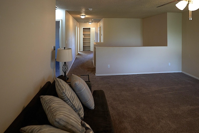 living room featuring a textured ceiling and dark carpet