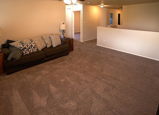 unfurnished living room featuring dark colored carpet and ceiling fan