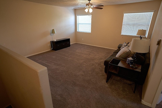 unfurnished living room featuring dark colored carpet, ceiling fan, and a textured ceiling