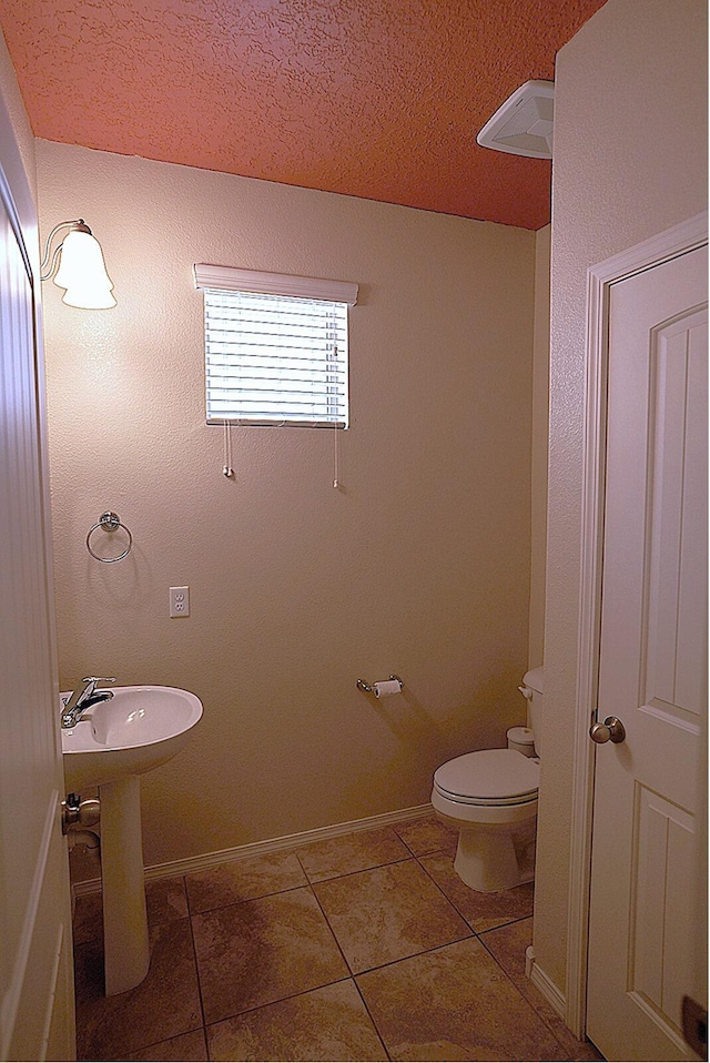 bathroom featuring sink, a textured ceiling, tile patterned floors, and toilet