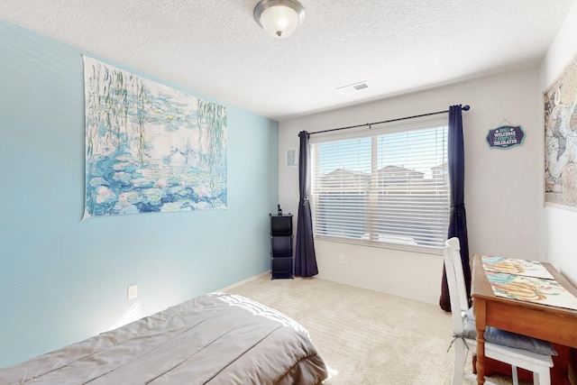 bedroom featuring light carpet and a textured ceiling