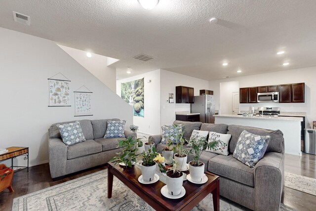 living room with dark hardwood / wood-style flooring and a textured ceiling