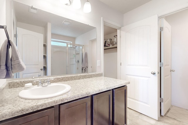 bathroom with vanity, a shower with door, and tile patterned floors