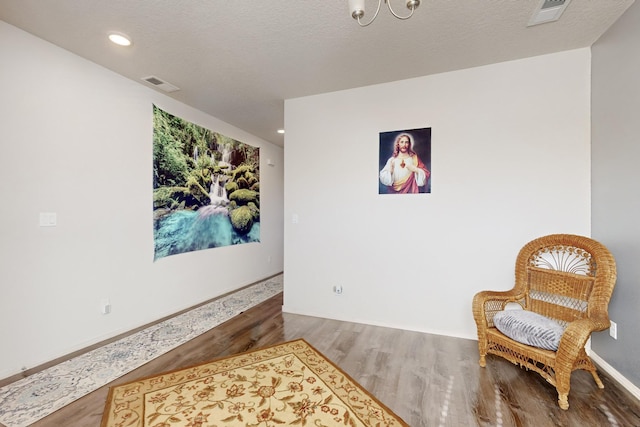 sitting room with hardwood / wood-style floors and a textured ceiling