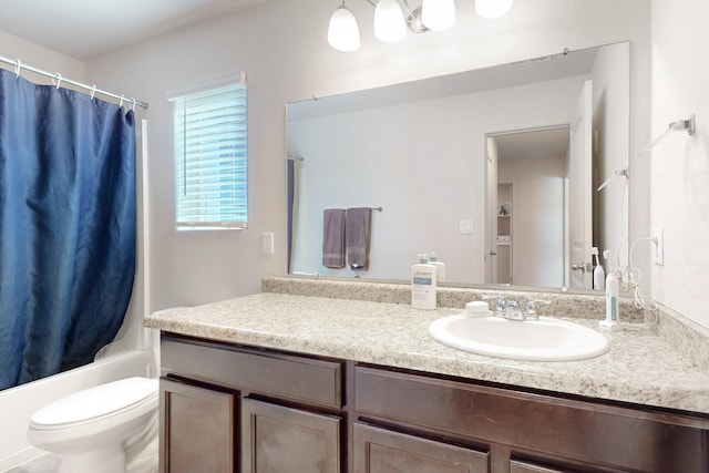 full bathroom with vanity, shower / bath combo with shower curtain, and toilet