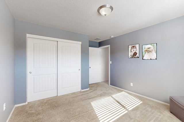 unfurnished bedroom with light carpet and a closet