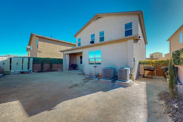 rear view of property with central AC