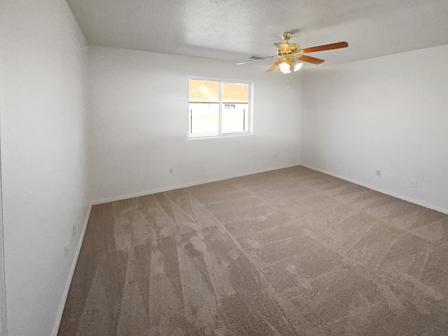 carpeted empty room with ceiling fan and a textured ceiling