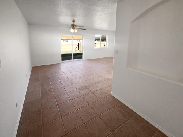 tiled spare room with ceiling fan and a textured ceiling