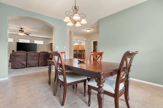 tiled dining space with ceiling fan with notable chandelier