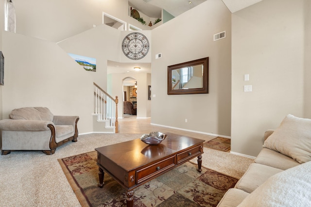 living room featuring a towering ceiling and carpet