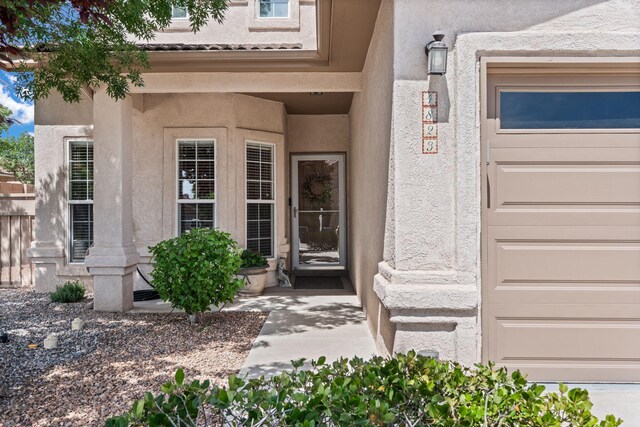 4823 Mcnary Ct NW, Albuquerque, NM 87120 - view of property hidden behind natural elements with stucco siding, concrete driveway, and an attached garage