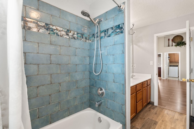 bathroom featuring shower / bath combo, hardwood / wood-style floors, vanity, a textured ceiling, and washer / clothes dryer