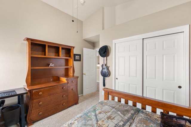 carpeted bedroom with vaulted ceiling and a closet