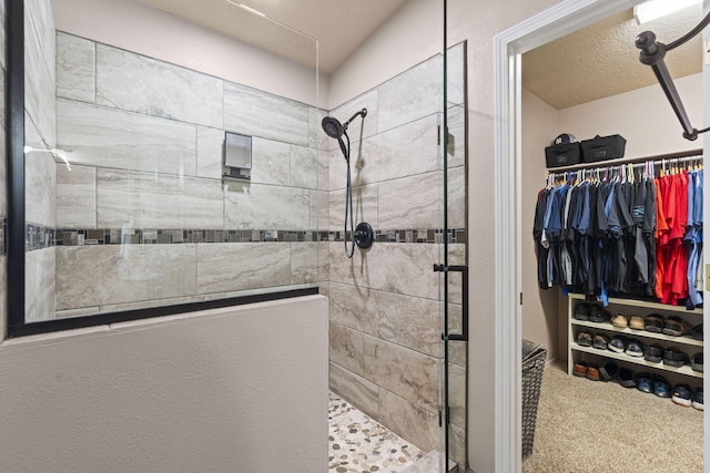 bathroom featuring tiled shower and a textured ceiling