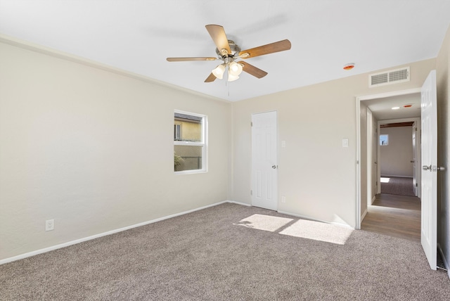 carpeted spare room featuring ceiling fan