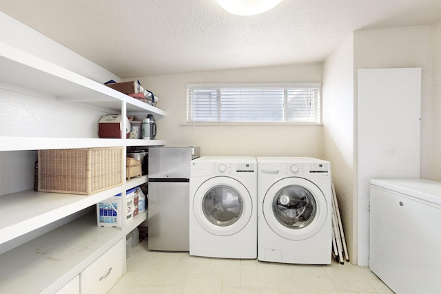 washroom featuring washing machine and clothes dryer and a textured ceiling