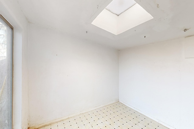 unfurnished room with a skylight