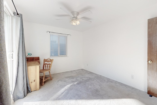 empty room featuring light colored carpet and ceiling fan