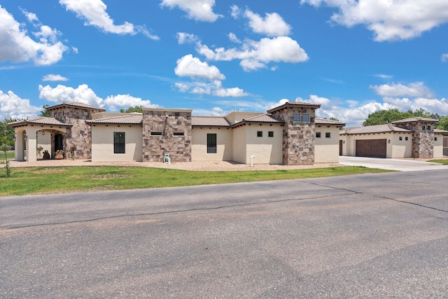 mediterranean / spanish-style house featuring a garage and a front lawn