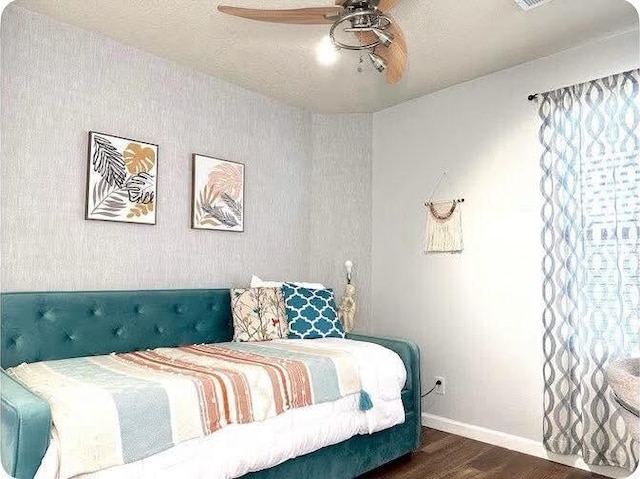 bedroom with ceiling fan, dark hardwood / wood-style flooring, and a textured ceiling