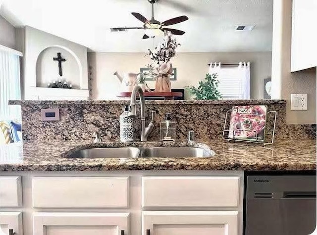 kitchen featuring white cabinetry, ceiling fan, dark stone counters, and sink