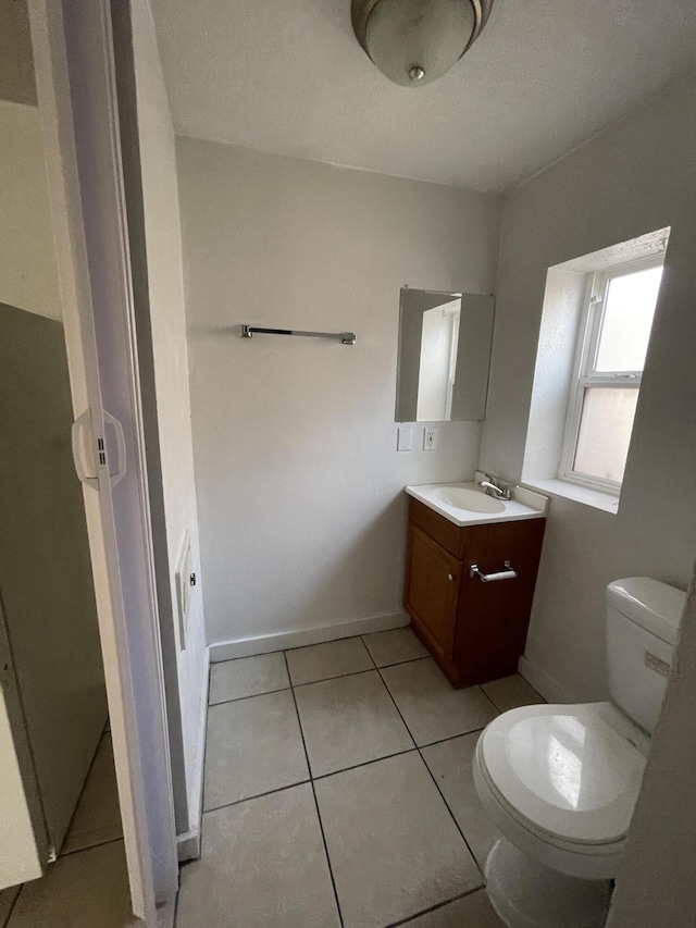 bathroom with tile patterned flooring, vanity, and toilet