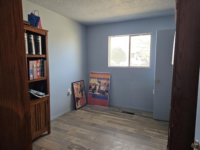 interior space with wood-type flooring and a textured ceiling