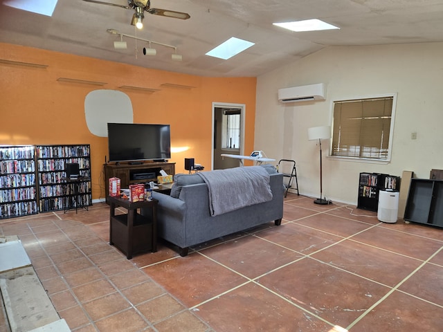 tiled living room with ceiling fan, a wall unit AC, rail lighting, and vaulted ceiling with skylight