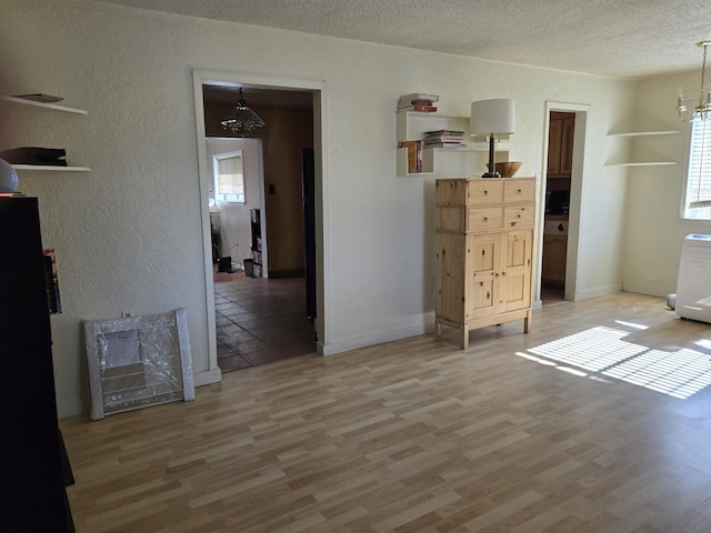 interior space featuring an inviting chandelier, radiator heating unit, wood-type flooring, and a textured ceiling