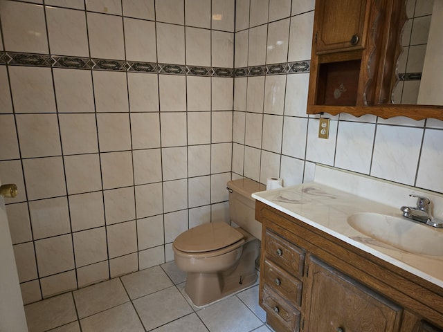 bathroom with tile walls, vanity, tile patterned flooring, and toilet