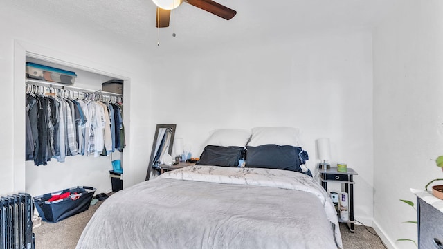 carpeted bedroom with radiator, ceiling fan, and a closet