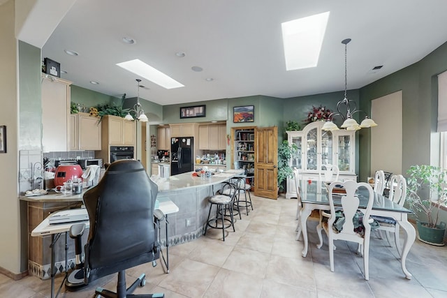 kitchen featuring a chandelier, decorative light fixtures, a skylight, and black appliances