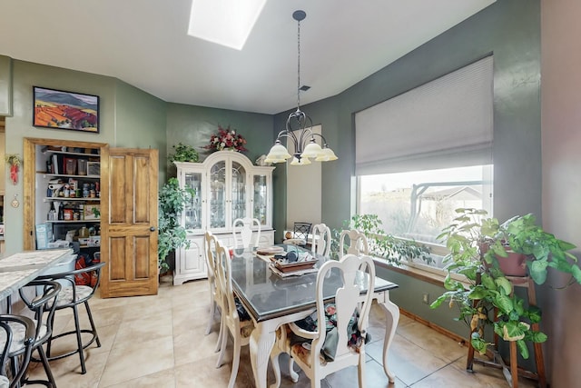 tiled dining area featuring a skylight and a notable chandelier