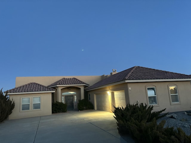 mediterranean / spanish-style home with a garage