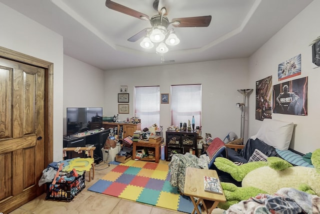 interior space featuring a raised ceiling and ceiling fan