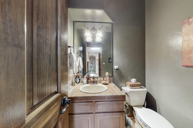 bathroom with vanity, a chandelier, and toilet