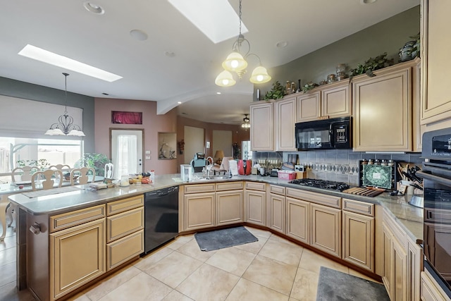 kitchen with a skylight, black appliances, decorative backsplash, decorative light fixtures, and kitchen peninsula