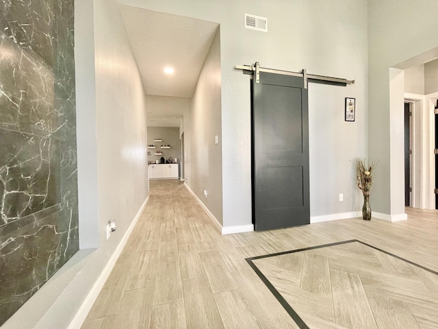 corridor featuring wood-type flooring and a barn door