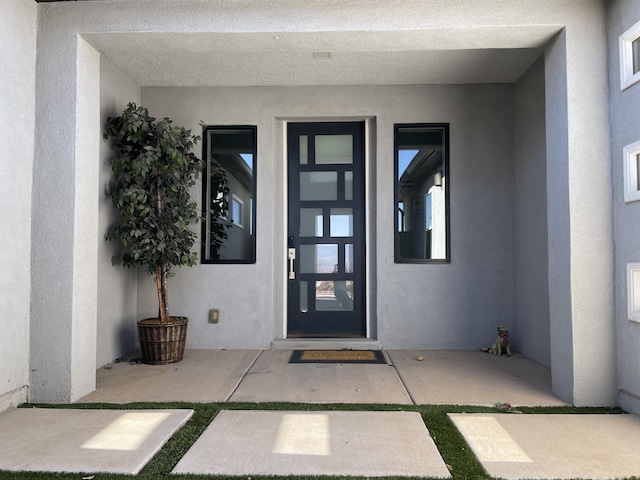 view of exterior entry with a patio