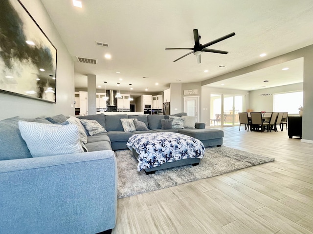 living room featuring ceiling fan and light hardwood / wood-style floors