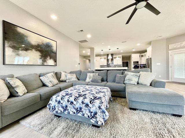 living room with ceiling fan and light hardwood / wood-style floors