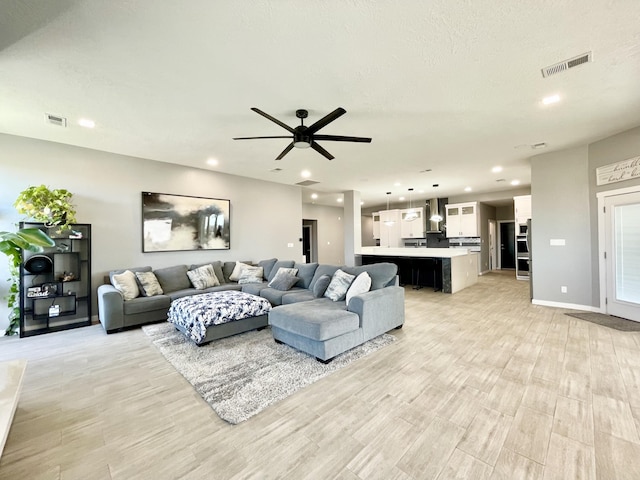 living room featuring ceiling fan and light hardwood / wood-style flooring