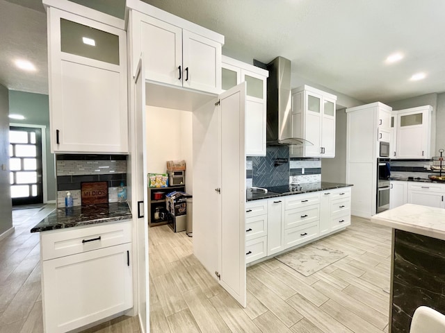 kitchen featuring white cabinetry, wall chimney range hood, beverage cooler, and dark stone counters