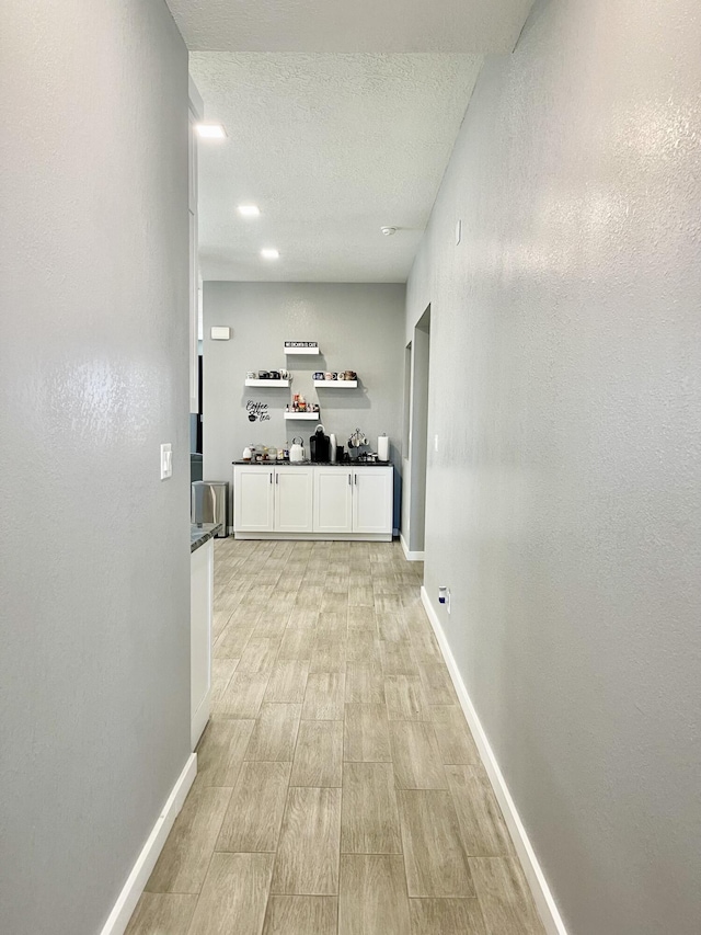 hall with a textured ceiling