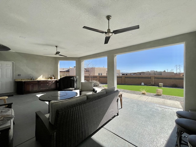 view of patio with area for grilling, sink, and ceiling fan