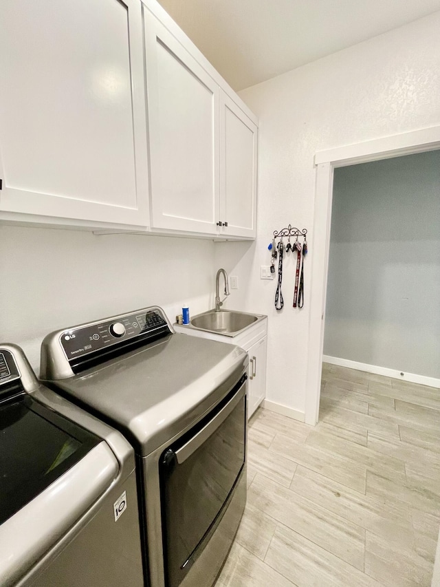 laundry room with sink, cabinets, and washer and dryer