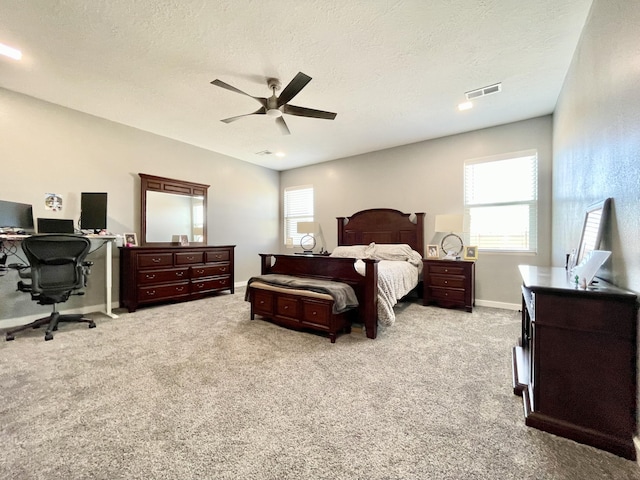 carpeted bedroom with multiple windows, a textured ceiling, and ceiling fan