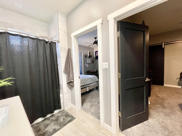 bathroom with shower / bath combo, vanity, and ceiling fan