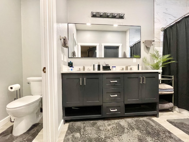 bathroom with vanity, curtained shower, and toilet